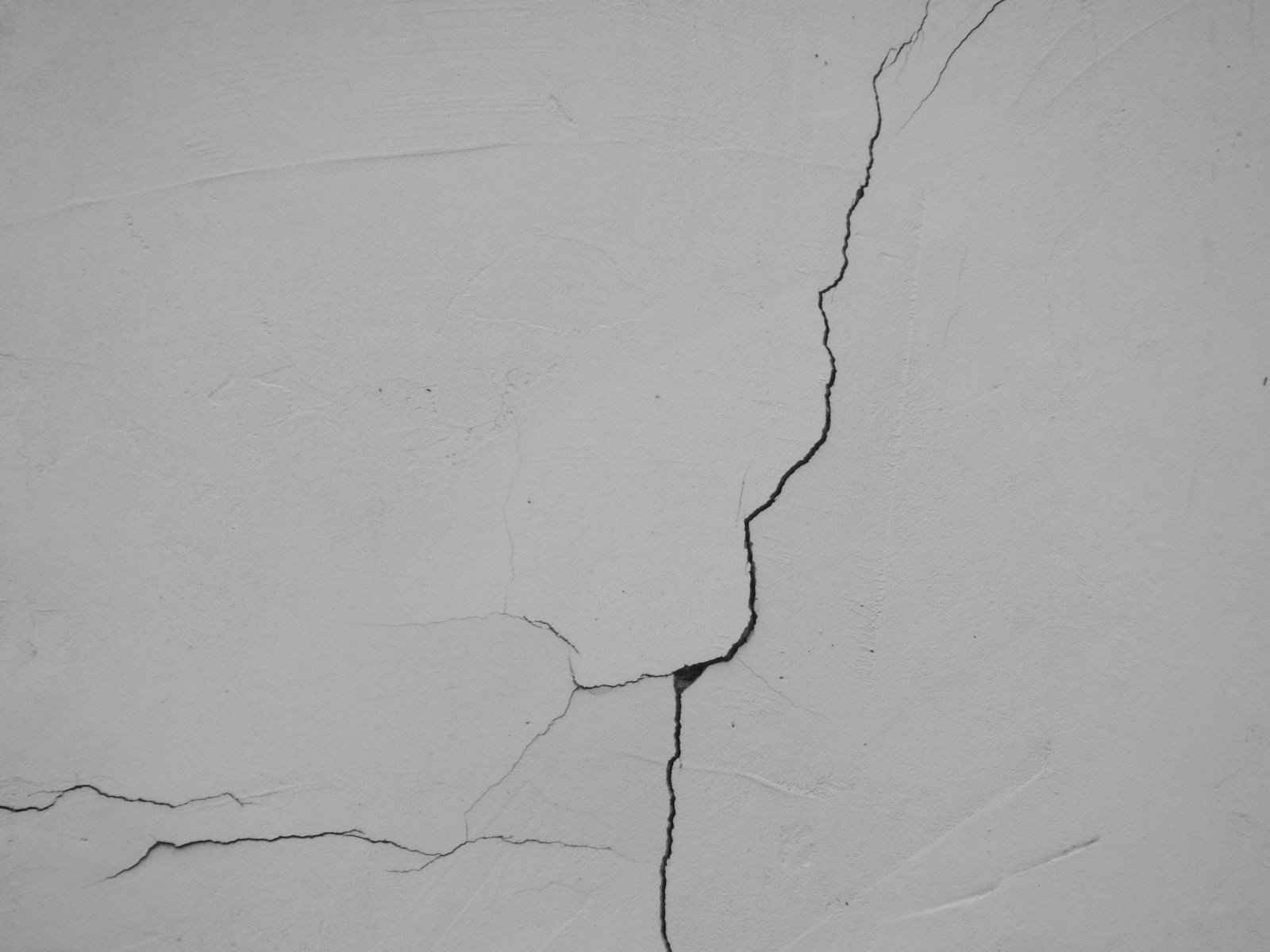 Enduit de façade fissuré sur le mur d'une maison