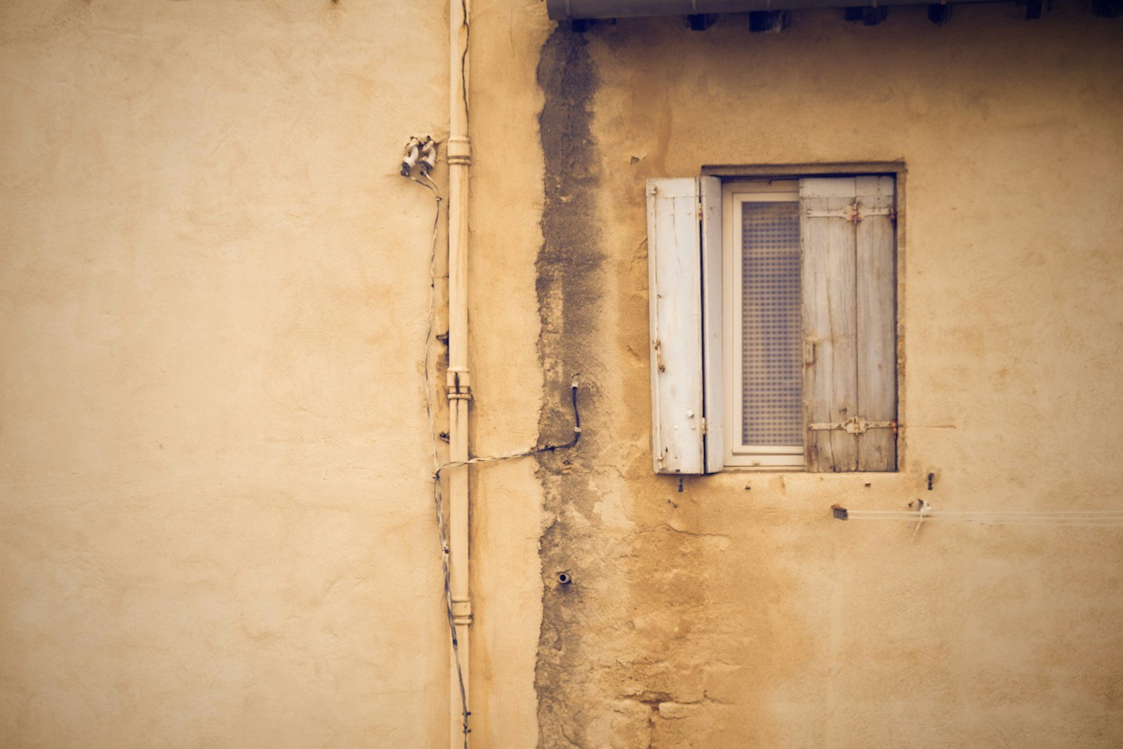 Tache d'humidité sur un mur, sous un chéneau qui déborde