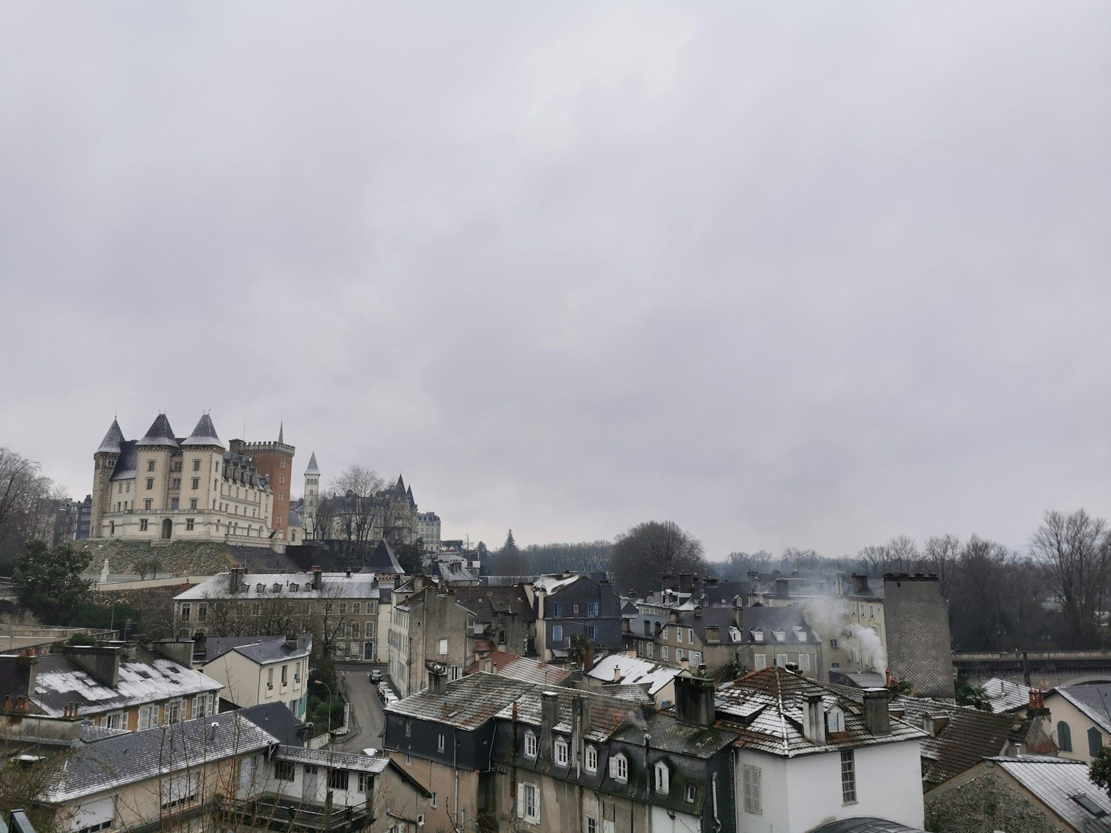 Toits d'une ville de fond de vallée dans la brume matinale